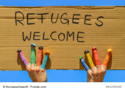 Refugees welcome - Hnde mit bunten Fingern halten ein Pappschild mit der Aufschrift "Flchtlinge willkommen"